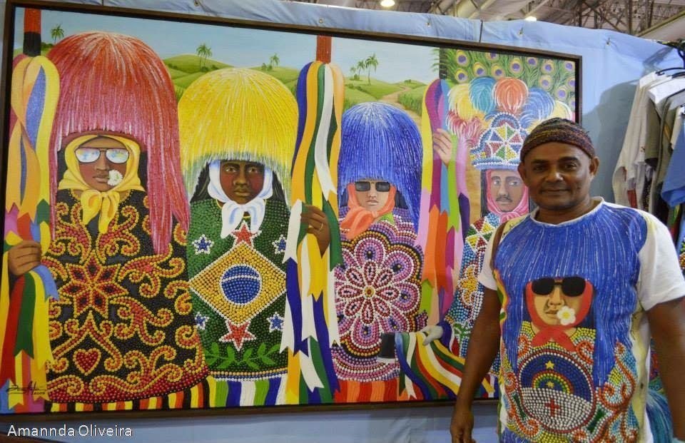 João Artur ao lado de uma de suas telas de maracatu