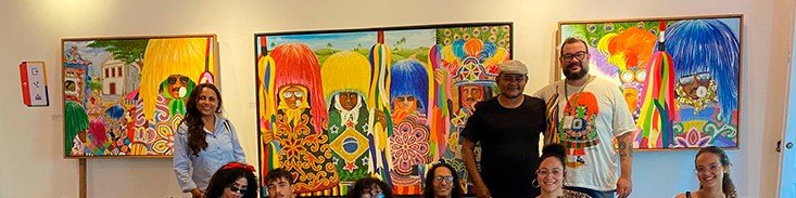 Visitantes diante das telas de João Artur durante exposição